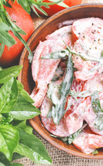 fresh salad with tomatoes and arugula in the sour cream, rustic