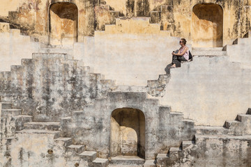 A tourist sitting in the step well in Jaipur, Rajasthan, India