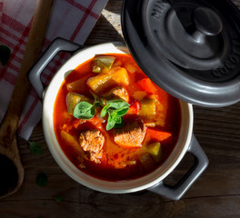 Gulasch in einer schwarzen cocotte mit Majoran.