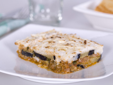 Closeup of a portion of moussaka, on a white plate