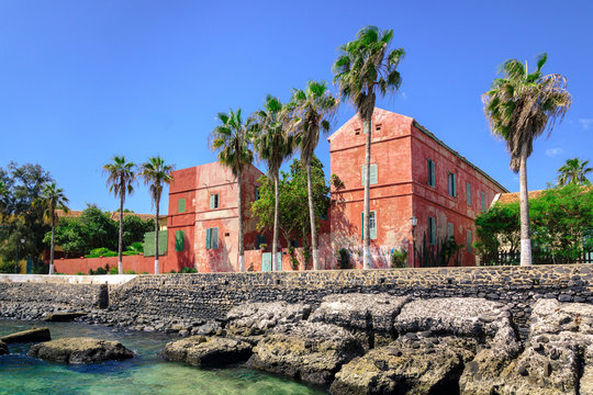 Старые красные дома на улице вдоль берега острова Goree, Сенегал