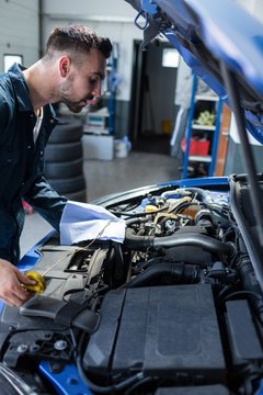 Mechanic checking the oil level in a car engine