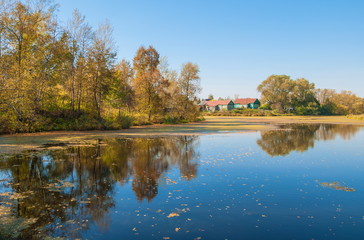 Fototapeta na wymiar Autumn landscape with a small village on the river bank