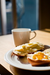 Breakfast: cup with a hot tea or coffee, bread with butter and jam