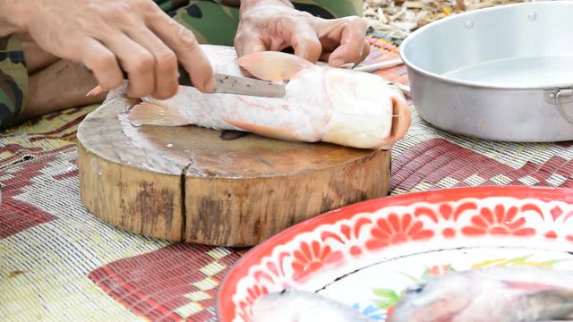 The chef was filleting fish with a knife.