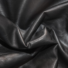 Black leather background in the folds