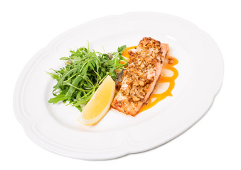 Baked salmon fillet with walnuts and arugula.