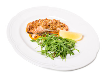 Baked salmon fillet with walnuts and arugula.