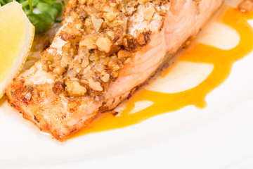 Baked salmon fillet with walnuts and arugula.