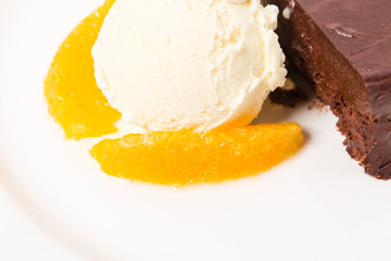Chocolate cake with ice cream scoop closeup.