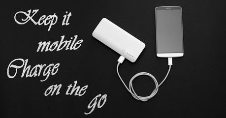 Smartphone and powerbank on blackboard with text