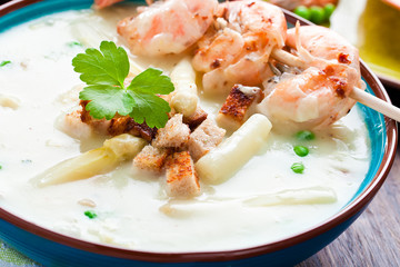 Frische Spagelcreamsuppe serviert mit garnellenspies 