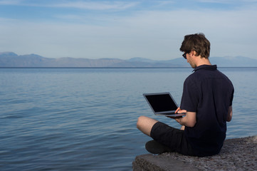 Young man working near the sea