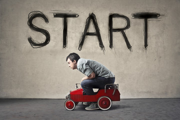 Man driving a toy car