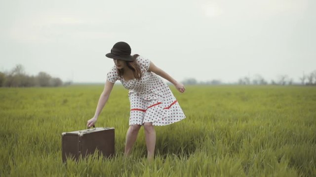 woman dressed in retro style relaxing on a green field slow motion
