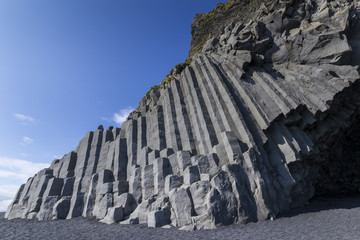 Rocky volcanic outcrop on black sands at Dyrhalaey near the town of Vik in Iceland