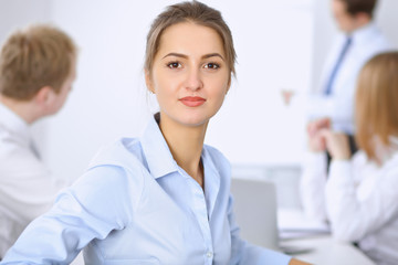Fototapeta premium Beautiful business woman on the background of business people during meeting