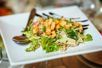 Caesar chicken salad with tomatoes, arugula and bread croutons