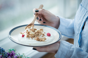 A cup of fresh yogurt in woman's hands