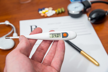 thermometer in hands of doctor on a background form RX