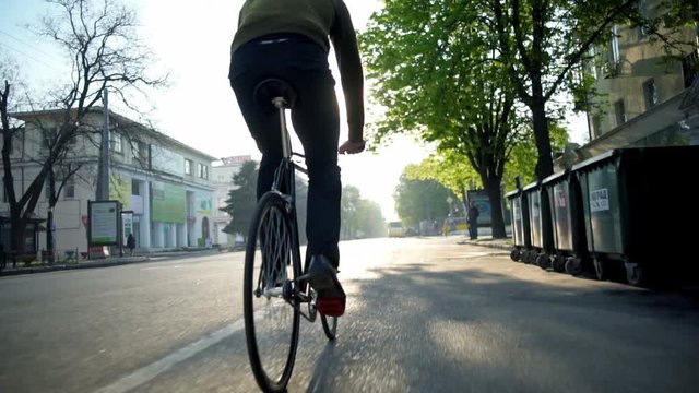 man riding a bicycle on the empty road slow motion