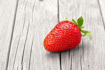 Fresh ripe strawberry on gray wooden table