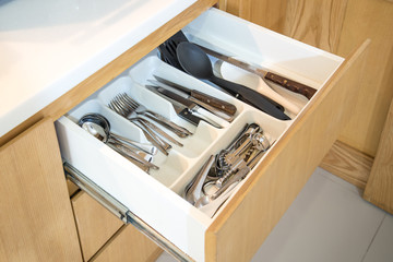 Open kitchen drawer with cutlery 