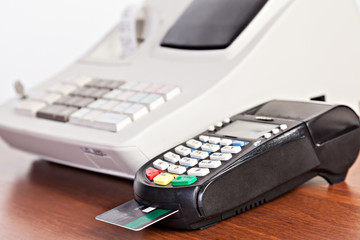 Close-up of cards servicing with POS-terminal on the cash regist