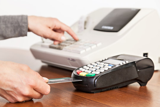 Hand push credit card Into a credit card machine. Close-up.