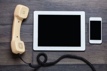 Old retro phone and new cell phone on wooden board, top view