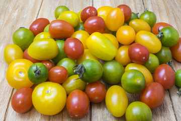 red, yellow and green tomatoes on a wooden table
