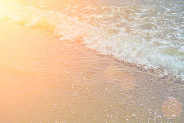 Soft wave of the turquoise sea on the sandy beach. Natural summer background with copy space