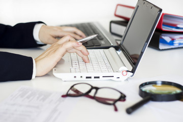 Businesswoman using laptop and calculator in the office