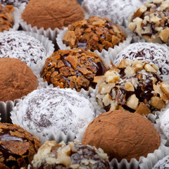 Round homemade chocolates in different kind of decor on paper su