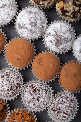Round homemade chocolates in different kind of decor on paper su