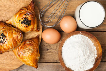 Triangular pies of puff pastry on a wooden background. Top view.