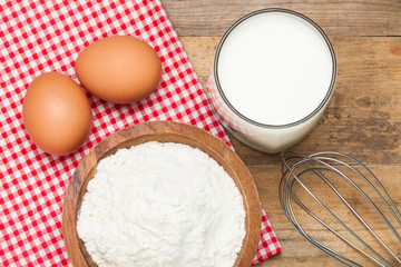 Eggs,flour, milk on a wooden worktop