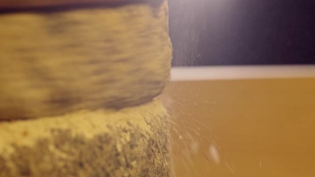 Close-up shot of historic hand-driven millstone grinding wheat