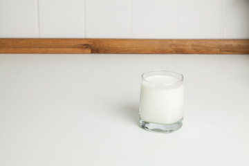 Glass of milk on white kitchen table table