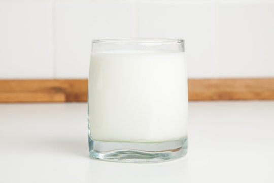 Glass of milk on white kitchen table table