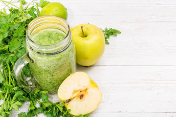 Smoothies with  apple, lemon, parsley in glass jars on a wooden background. Concept of cooking.