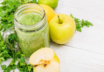 Smoothies with  apple, lemon, parsley in glass jars on a wooden background. Concept of cooking.