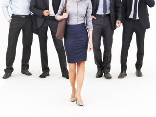 Image of a group of young businessmen standing with a businesswoman walking in front. Leading the way, diversity or harassment concept. Photo realistic 3d model scene
