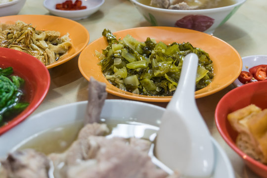 Chinese local foods on table, bak kut teh, vegetables, tofu and chili side dishes, selective focus on vegetable