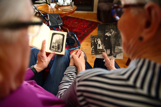 senior/ elderly couple looking at  their wedding photo's together