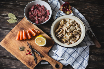 meat, mushrooms, tomatoes, vegetables and spices lie 