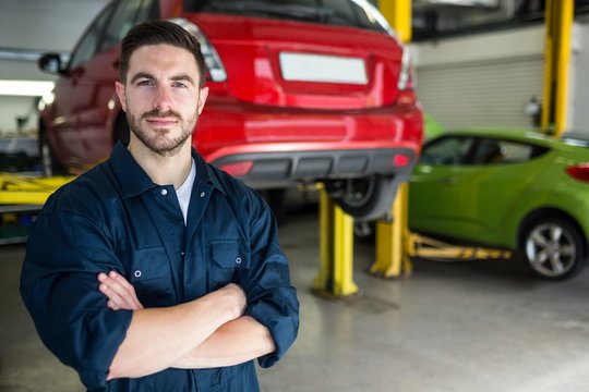 Mechanic with arms crossed smiling at camera