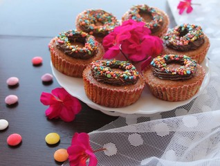 pumpkin cupcakes with chocolate cream and colored sprinkles