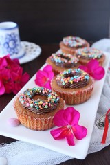 pumpkin cupcakes with chocolate cream and colored sprinkles