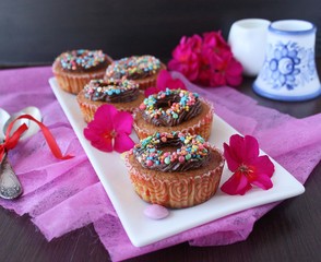 pumpkin cupcakes with chocolate cream and colored sprinkles